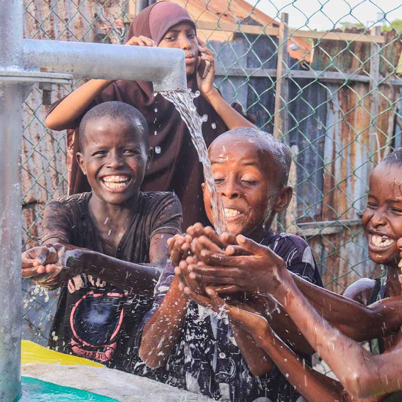 Children drinking clean water from well