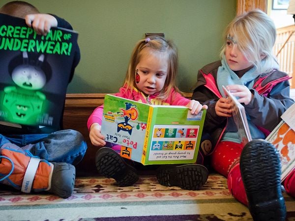 Girl reading book upside down